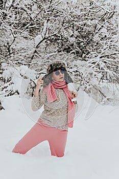 Young woman in sunglasses and a wine glass filled with snow. Woman misses relaxing on the beach