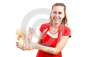 Young woman supermarket employee presenting frozen meat product