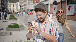 Young woman surprises waiting man by covering his eyes.