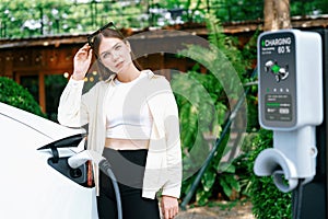 Young woman and sustainable urban commute with EV at cafe. Expedient photo