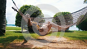 A young woman in swim suit lying in the hammock and enjoy her holidays