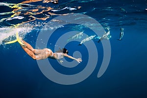 Young woman swim underwater with dolphins in ocean. Mauritius