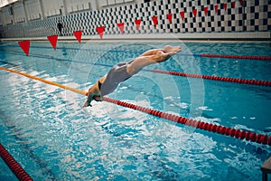 Young woman swimmer jump swims in swimming pool