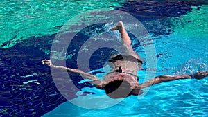 Young woman swimming in a blue pool