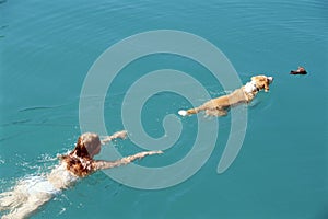 Young woman swimming with dog