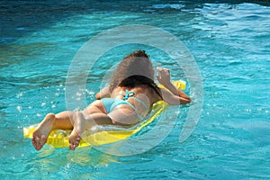 Young woman swimming on mattress