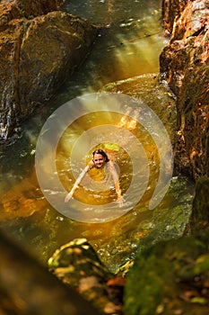 Young woman swimming in a natural tropical pool