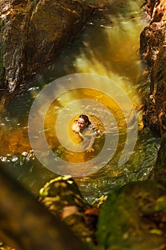 Young woman swimming in a natural tropical pool