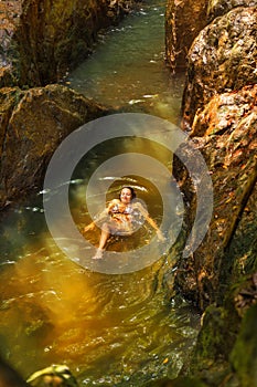 Young woman swimming in a natural tropical pool