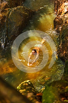 Young woman swimming in a natural tropical pool