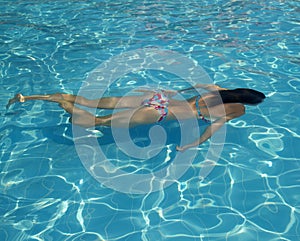 Young woman swimming under water