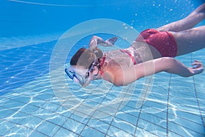 young woman swimming underwater in a pool