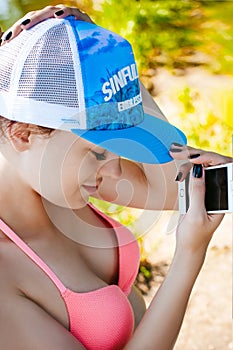 Young woman in swimsuit in snapback on her head