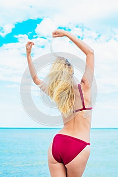 Young woman in swimsuit and sunglasses relax on beach in the sea