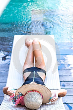 Young woman in swimsuit in swimming pool in gorgeous resort, luxury villa, tropical Bali island, Indonesia.