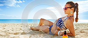 Young woman in swimwear on seacoast sunbathing