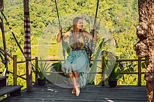 Young woman swinging in the jungle rainforest of Bali island, Indonesia. Swing in the tropics. Swings - trend of Bali