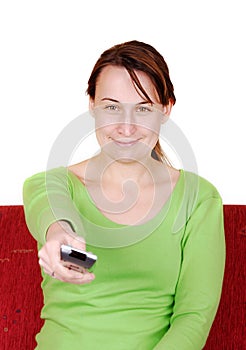 Young woman switches with remote control