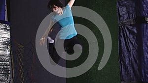 A young woman in a T-shirt. Jumping on a trampoline is ridiculous.