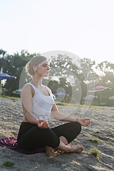 A woman meditates on the beach photo