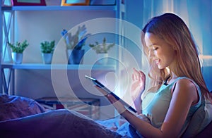 Young woman with tablet computer in a dark room