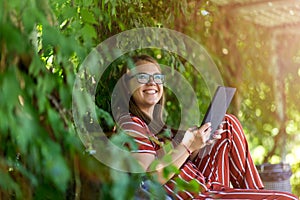 Young woman with tablet computer in the park