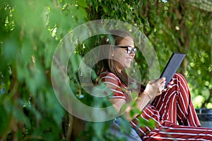 Young woman with tablet computer in the park