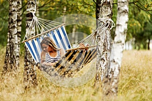 Young woman with tablet on the hammock