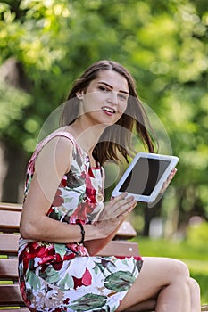 Young Woman with a Tablet in a Park