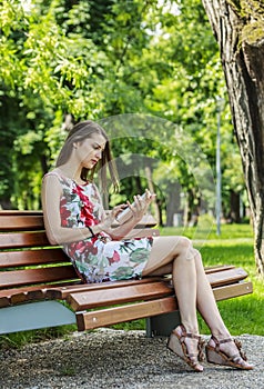 Young Woman with a Tablet in a Park