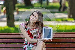 Young Woman with a Tablet in a Park