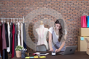 Young woman tailor with laptop is answering emails, Business woman entrepreneurial success . Sales Online Parcel delivery