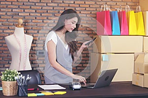 Young woman tailor with laptop is answering emails, Business woman entrepreneurial success . Sales Online Parcel delivery