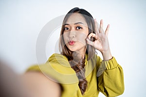 young woman take a selfie with ok hands gesture