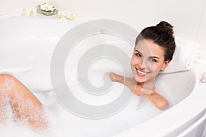 Young woman takes bubble bath