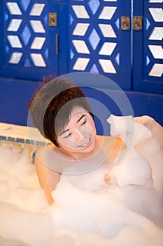 Young woman takes bubble bath