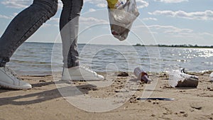 Young woman takes care of environment picking up trash