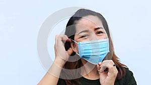Young woman takes off medical mask.