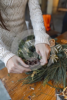 A young woman takes part in a crafting workshop, making festive Christmas ornaments.