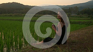 Young woman takes photos 0f the rice fields at sunset