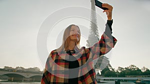 Young Woman takes Selfie Photo by Smartphone with Eiffel Tower in Paris, France