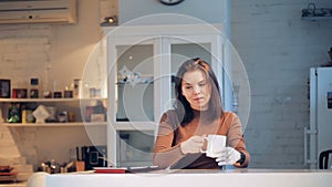 Young woman takes a tablet from a table, wearing robotic hand, close up.