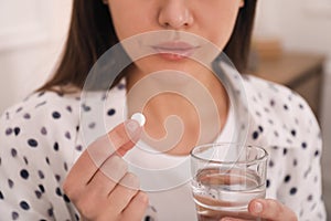 Young woman taking abortion pill, closeup