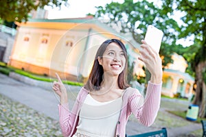 Young woman taking image by mobile phone in Macao