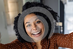 Young woman taking a joyful selfie in a modern home