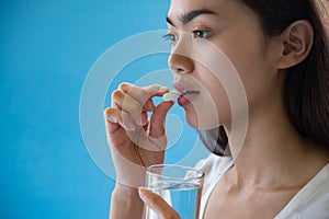 Young woman taking medicine pill