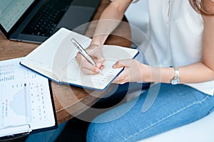 young woman taking notes in a notebook. close-up.