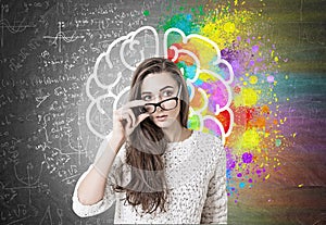 Young woman taking off glasses, brain, formulas