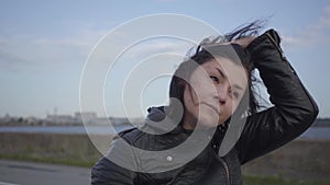 The young woman taking off the motorcycle helmet and looking into the camera smiling close-up. Hobby, traveling and