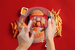A young woman taking photo of food on smartphone, photographing meal with mobile camera